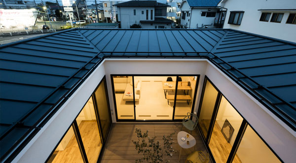 シンボルツリーを望むミニマルな回廊の家