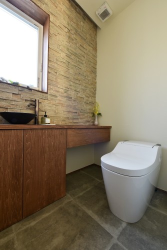 タイルを施したトイレは造作収納で内装を統一