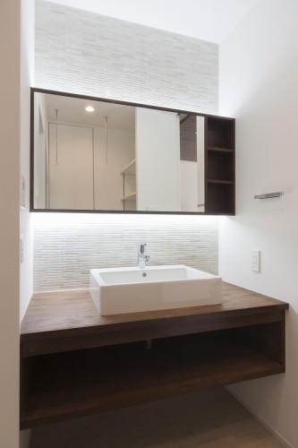 白壁と造作カウンターがモダンで上品な洗面室