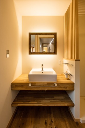 間接照明の木製のカウンターの洗面所