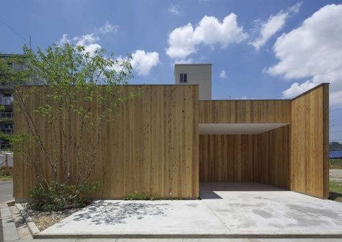 木材の壁の植栽のある平屋