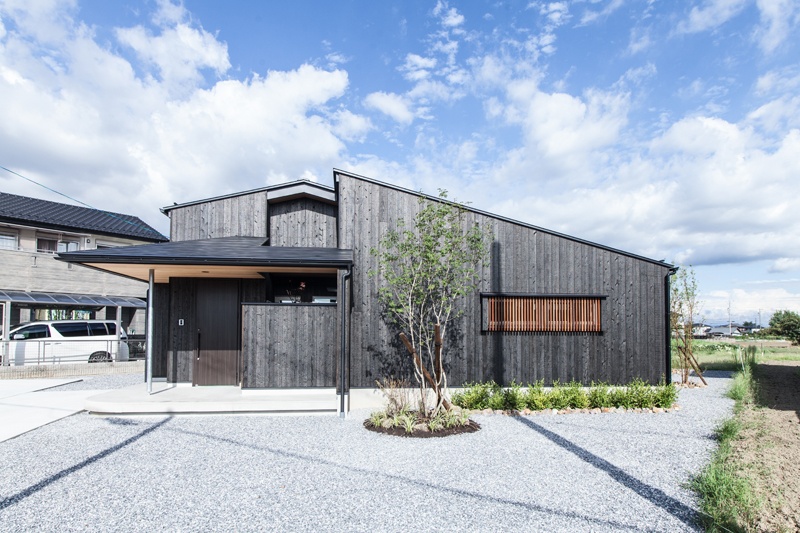 黒い板張りの平屋風の2階建の家