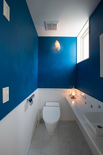 タイル床と白と青の壁があるトイレ