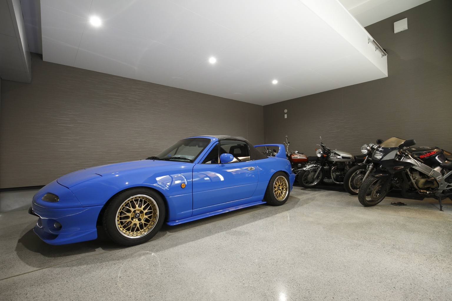 青いスポーツカーが駐車するビルトインガレージ