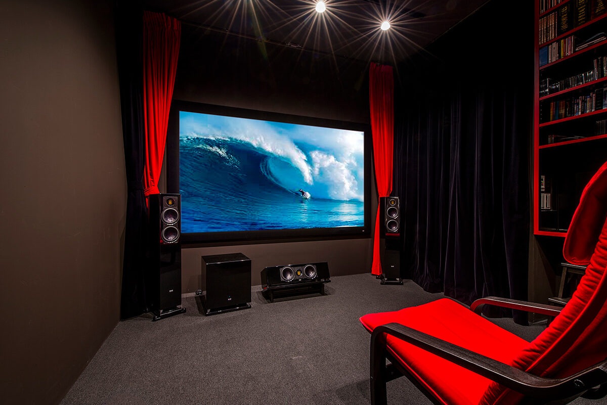 赤いカーテンと黒い壁で小さな映画館のような内装のシアタールーム