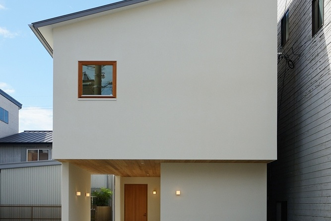 塗り壁と木製サッシの組み合わせと板張りの軒天