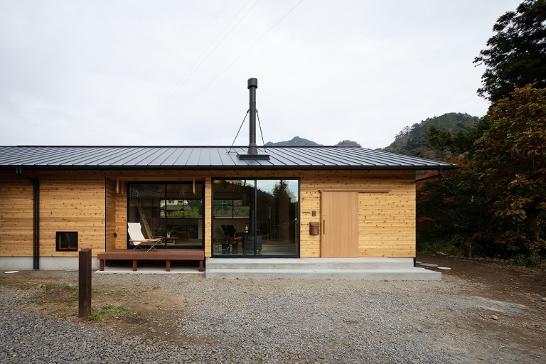 大自然に佇む薪ストーブが似合う山小屋風な切妻屋根の平屋