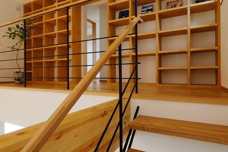スチールでデザインされた階段を上がるとﾎｰﾙの一画に設けられた大容量の本棚。