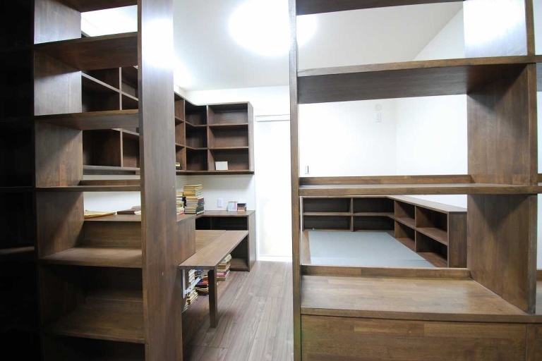 個人事務所の本棚と机。室内の間仕切りを兼ねた本棚があり、机も作り付けのオーダーメイドになっています。