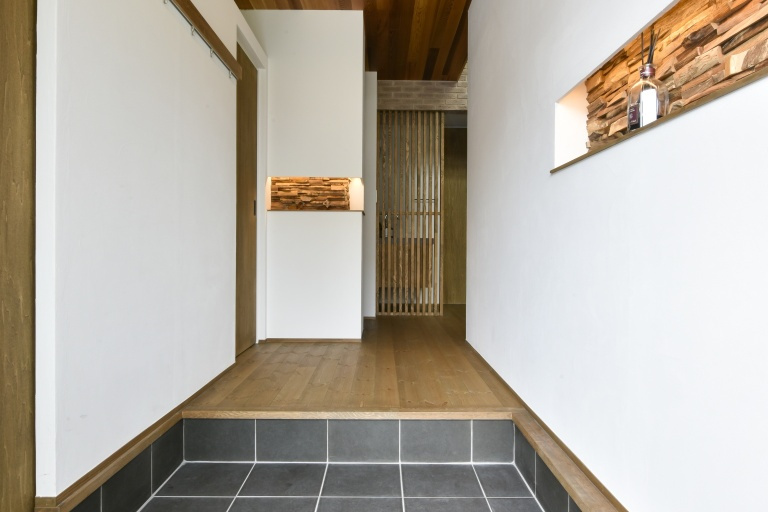 白い珪藻土の壁と木の温もり溢れる玄関