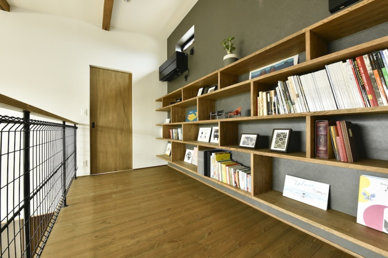 壁面の仕上げに変化をつけた家族の本棚は特別な空間に
