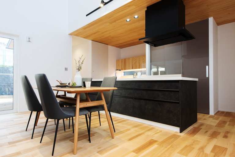自然素材の国産の木材の天井の板張りは回遊できるアイランドキッチンを印象的な空間造形としている。デザイン性も良く、ガレージハウスでもおすすめしたい。