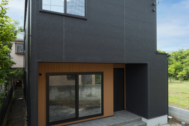 ブラックのタイル調の外壁と木目調の外壁を合わせて、スタイリッシュな外観