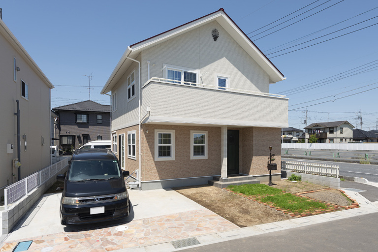 レンガ風の外壁と赤い三角屋根の外観