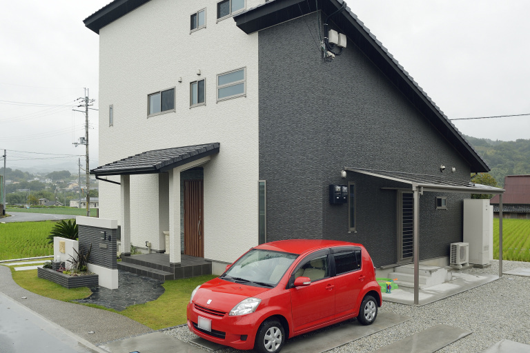 自然豊かな田園風景に佇むツートンカラーの外観