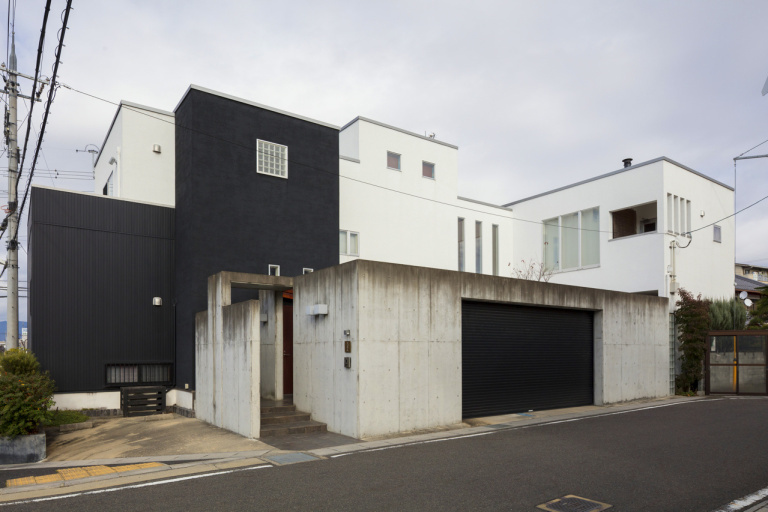 中庭を囲むように構成されたシックで落ち着いた印象の外観とガレージスペース