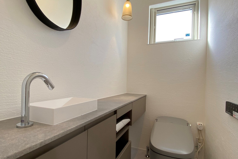 CUCINAのオーダー収納カウンターのあるデザインされたトイレ空間
