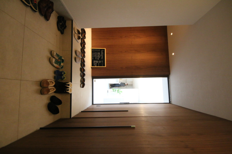 木の建具と壁が印象的な玄関ホール