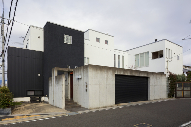 中庭を囲むように構成されたシックで落ち着いた印象の外観とガレージスペース