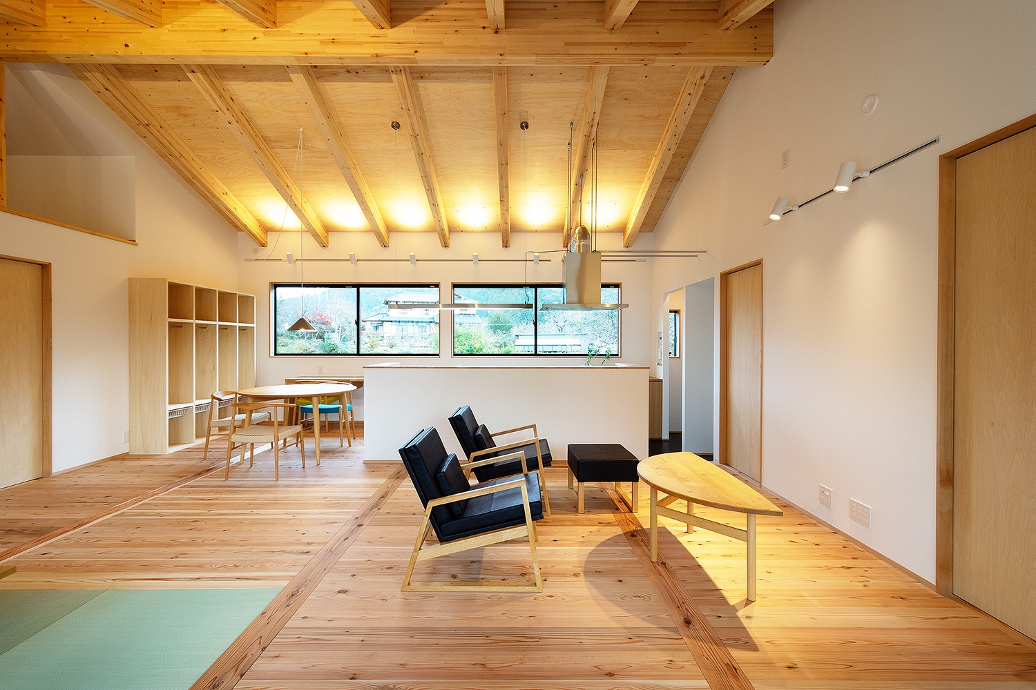 構造用合板と梁の現しがおしゃれな勾配天井いレザー張りのオリジナルの無垢の家具。