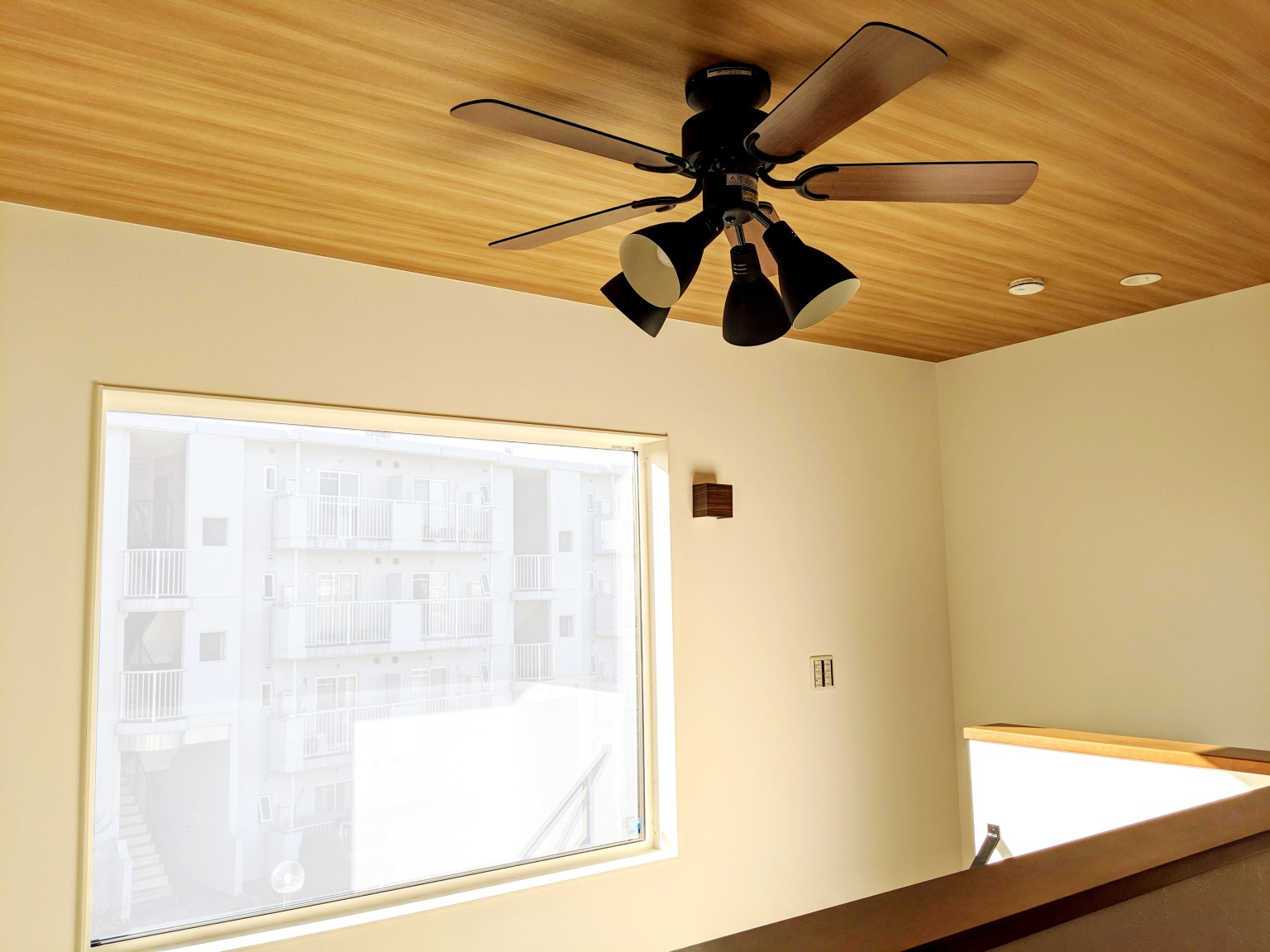 木目調の天井とダークカラーのシーリングファンが心安らぐ大人の空間を演出