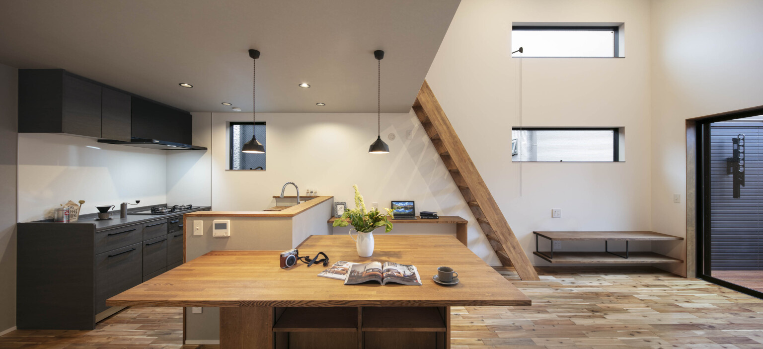 コンパクトなキッチンと大きなダイニングテーブルのあるLDK｜木造住宅×アウトドアリビング×おしゃれな家