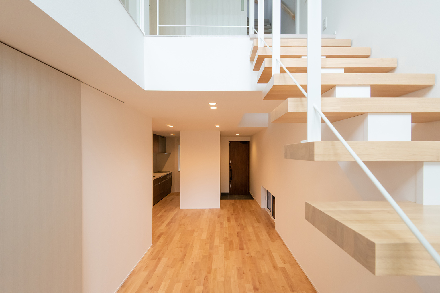 白いアイアン＋自然素材の木材のスケルトン階段。狭小住宅のデメリットとなる狭さを、開放的な3層吹き抜けでオシャレに解決した都市型住宅。