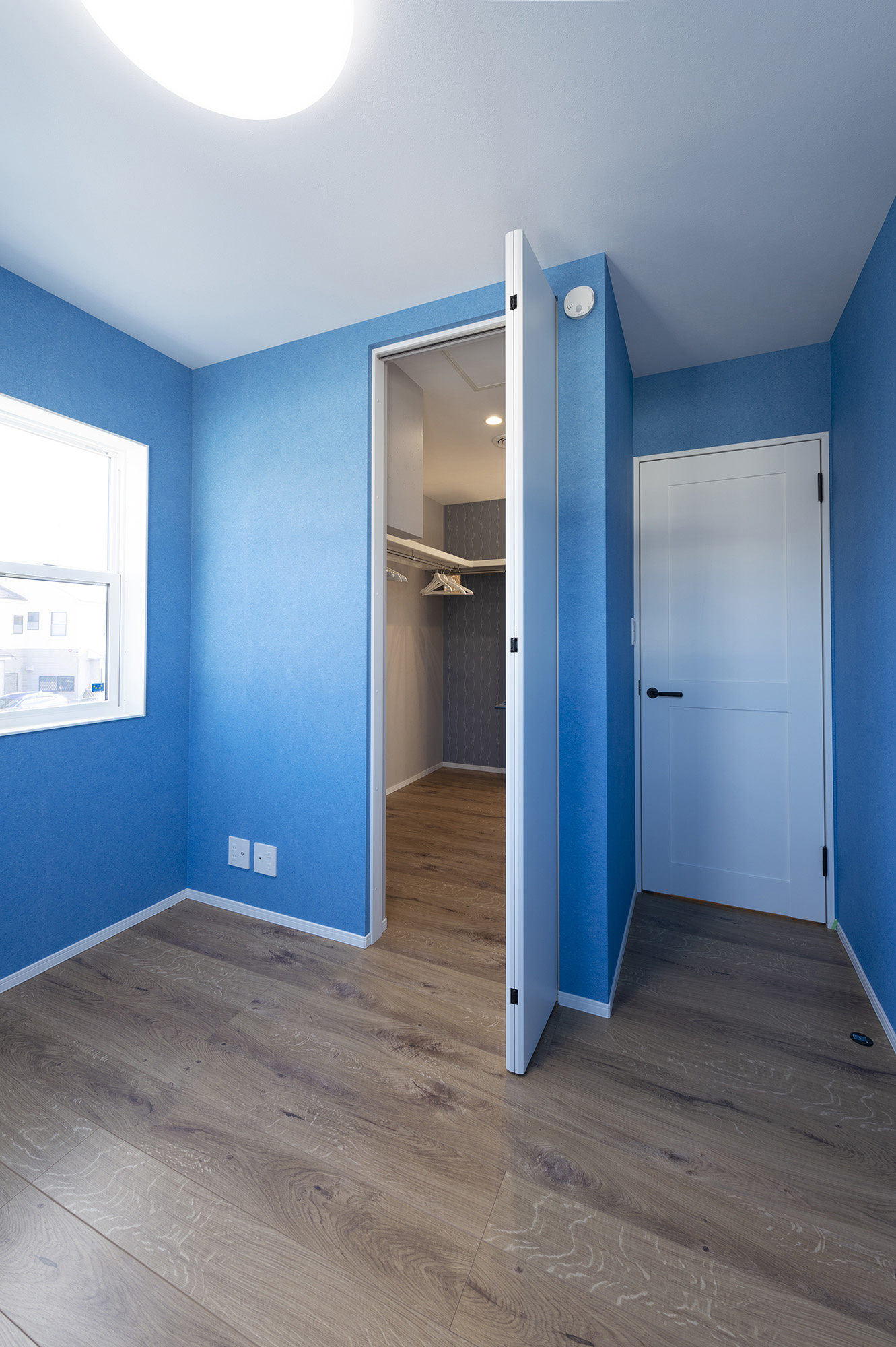鮮やかなブルーの壁紙が印象的なお子様部屋