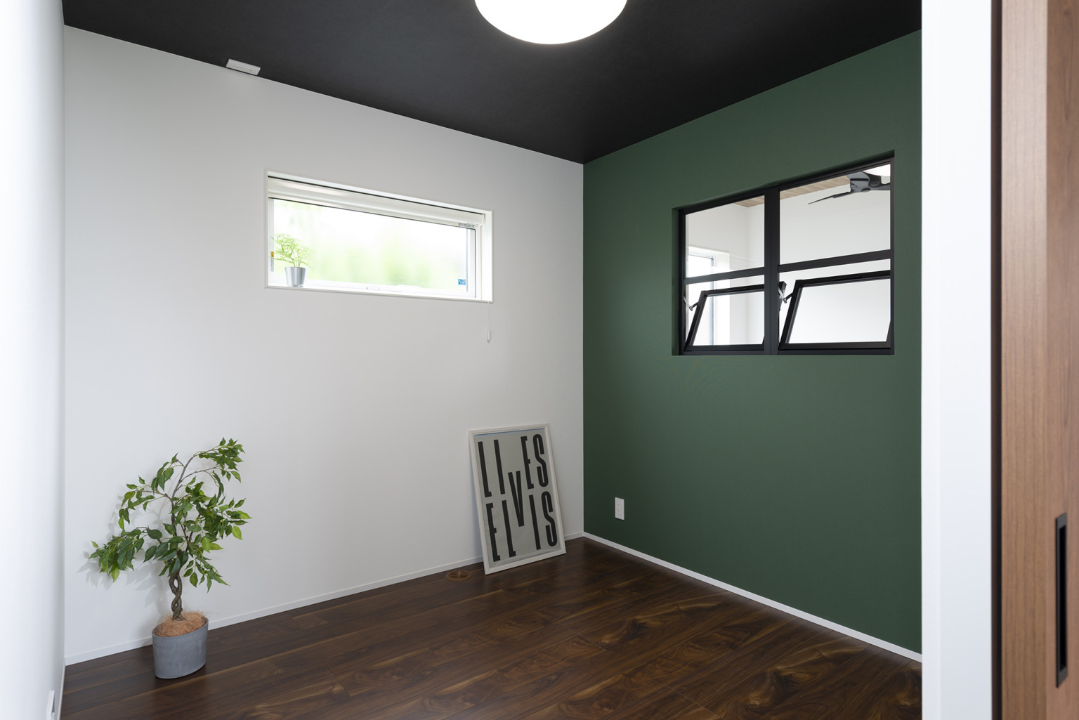 アクセントクロスのグリーンとブラックのデザイン窓で、お洒落な寝室