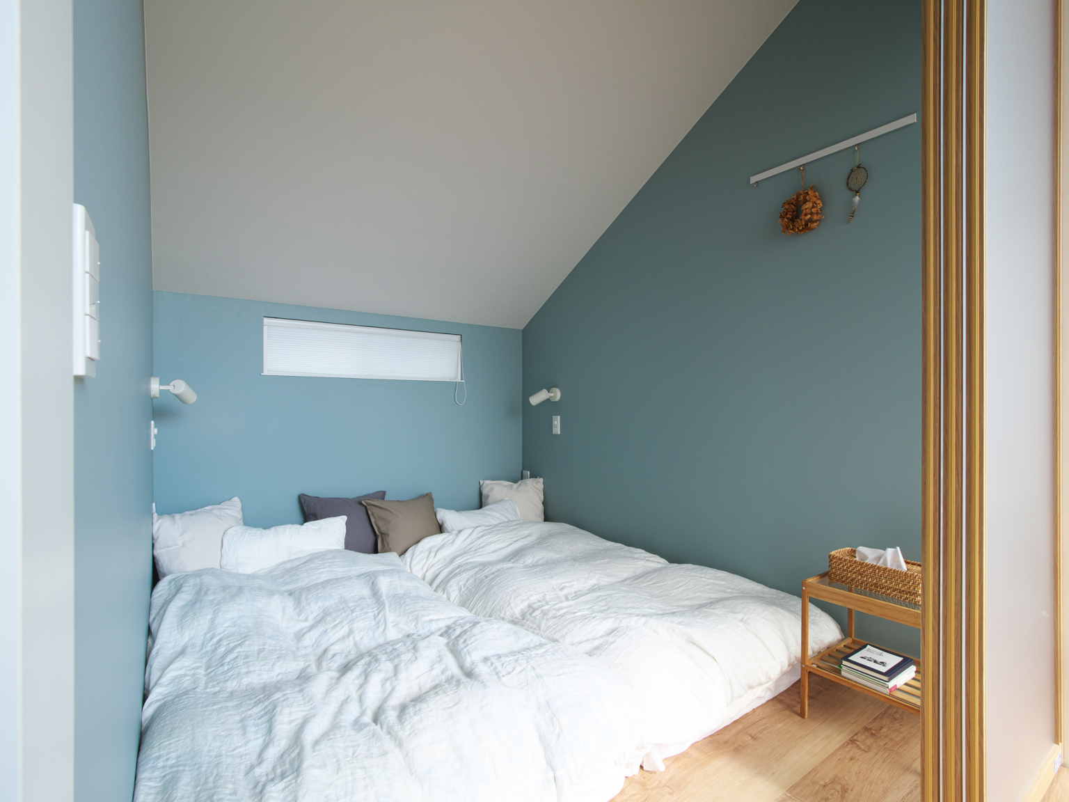 スモーキーブルーのクロスが魅力的な寝室。