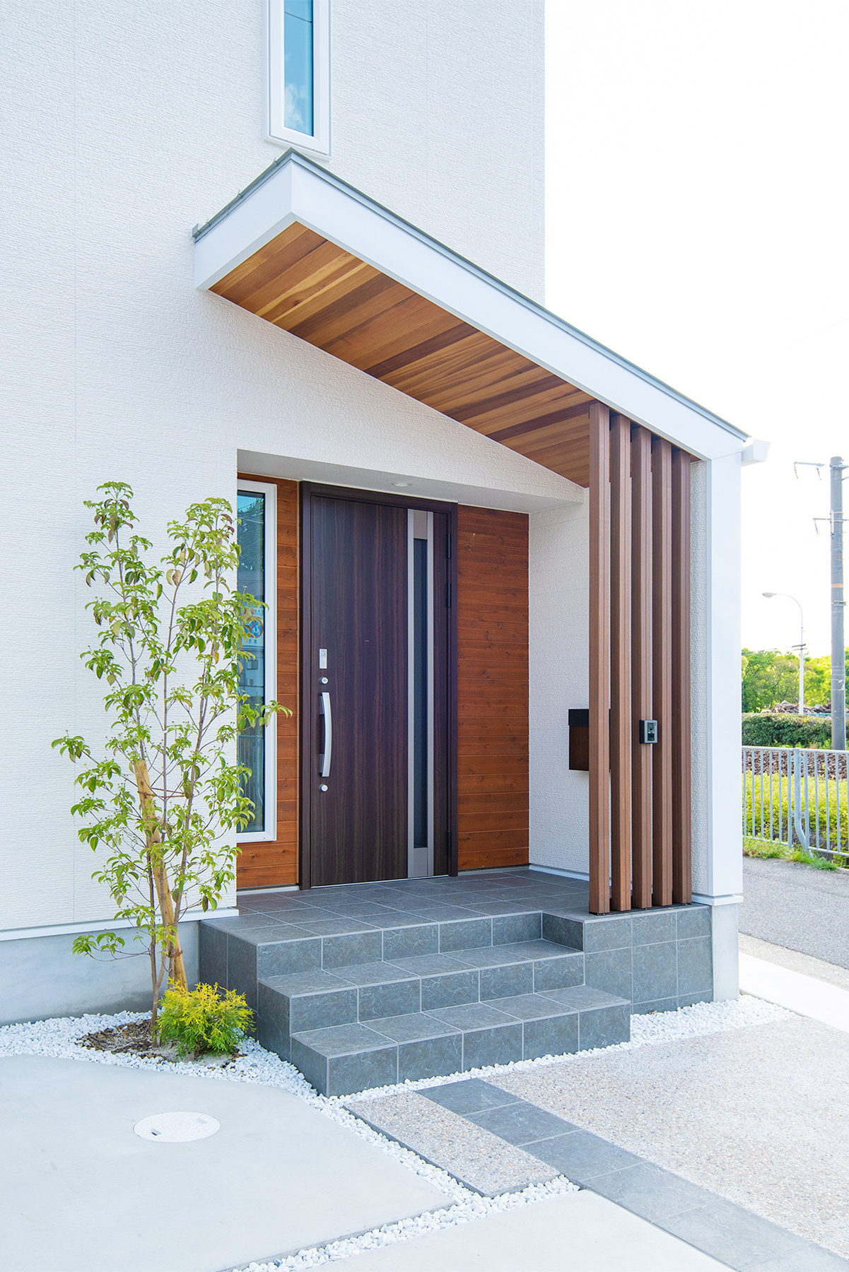 玄関アプローチ、ポーチは随所に天然木材を使用している。勾配天井の多いガレージハウスや平屋間取りでも人気がある。