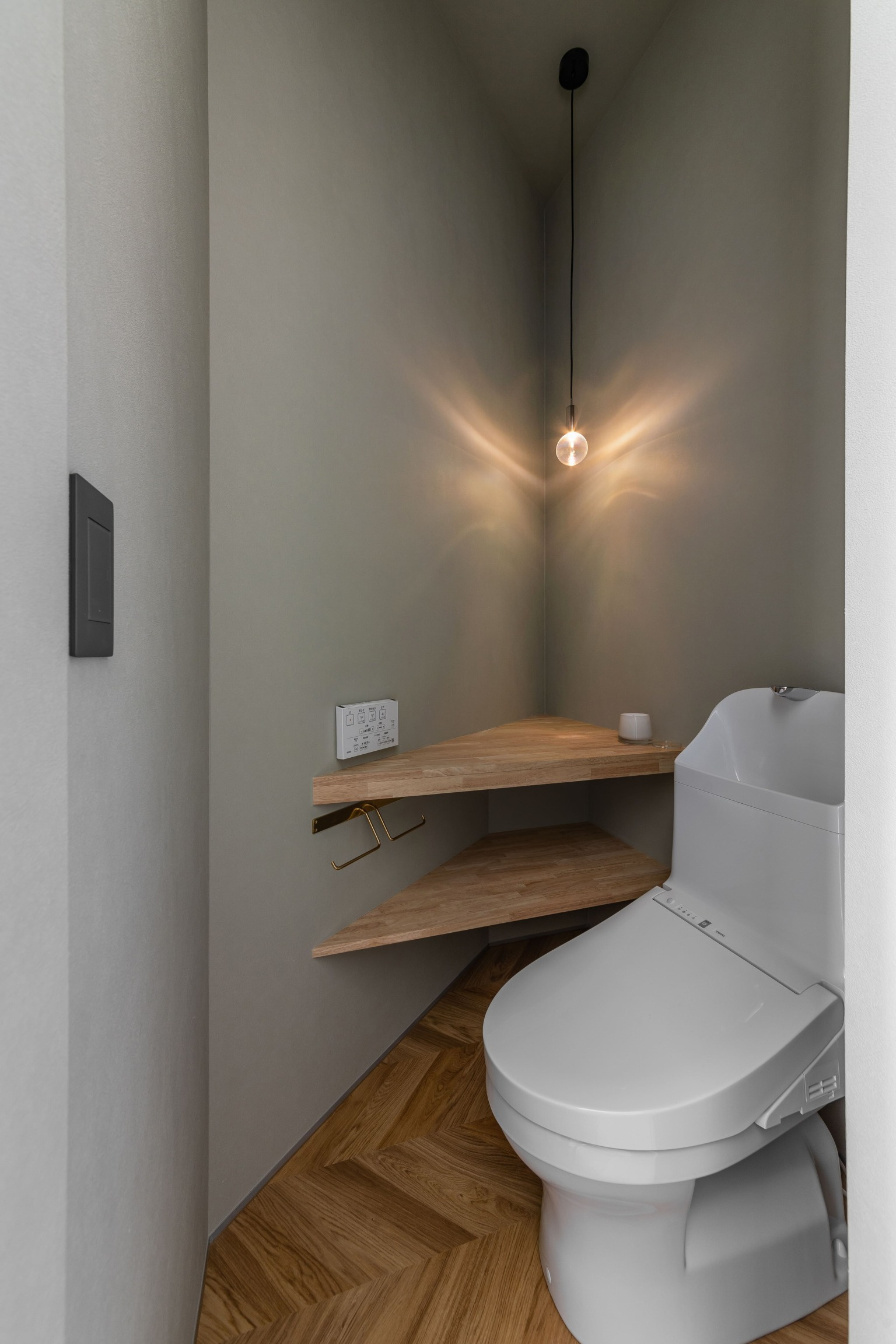 異形のトイレ空間と壁に反射する照明がオシャレで印象的なトイレに。