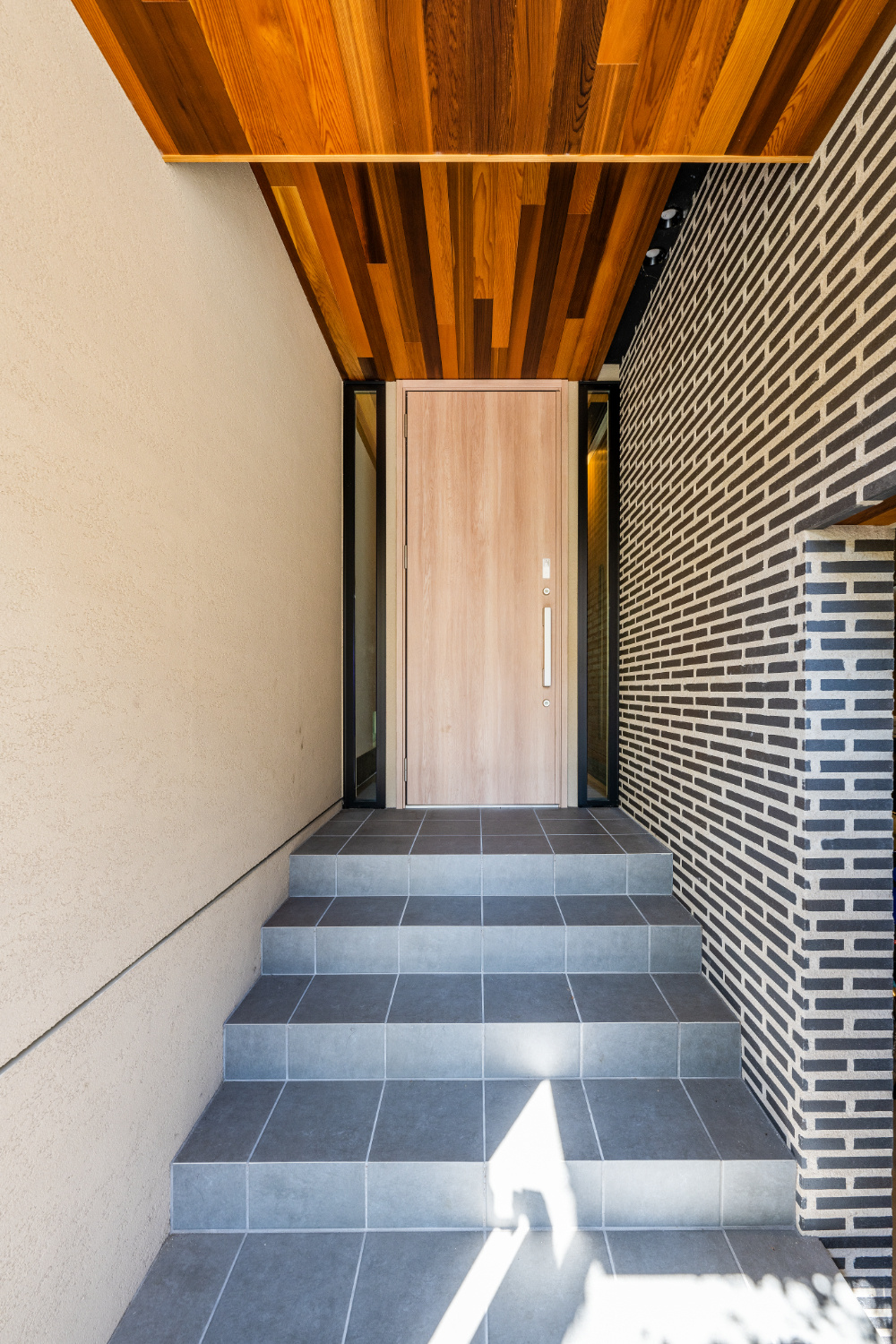 【神戸】ビルトインガレージとバルコニーに面したタイル壁が印象的な外観