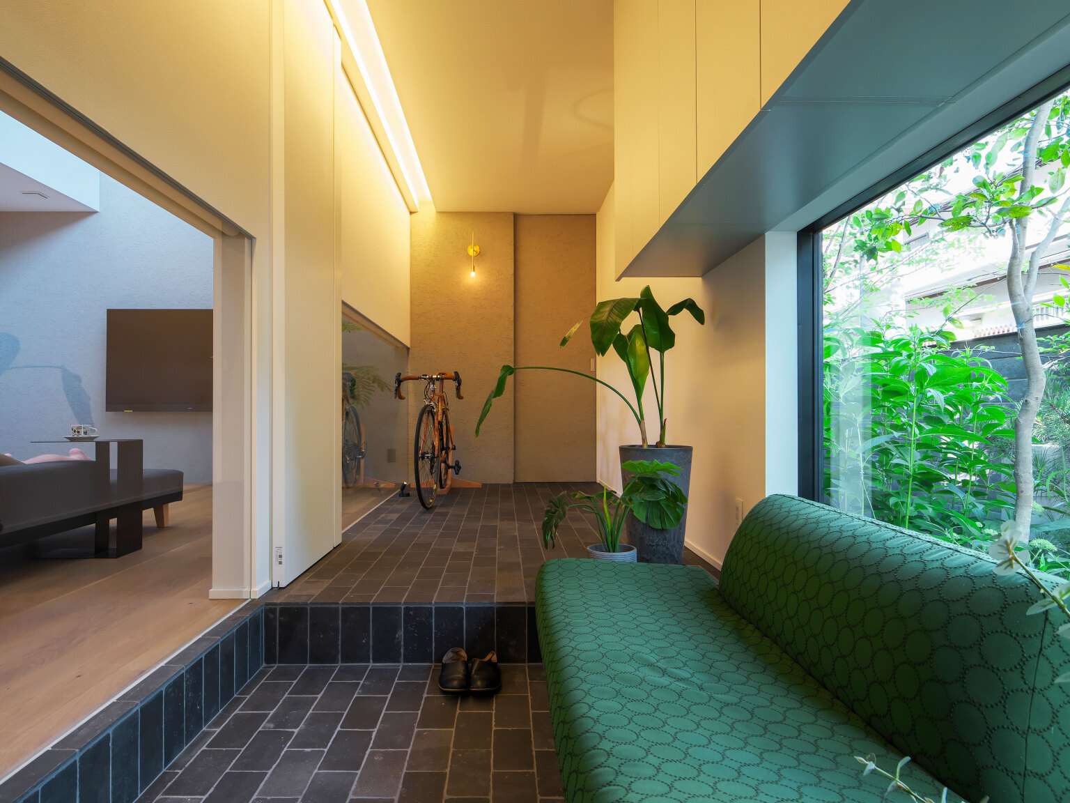 差し色としてソファのグリーンが外の植栽と呼応し、自然と暮らしをつなげます