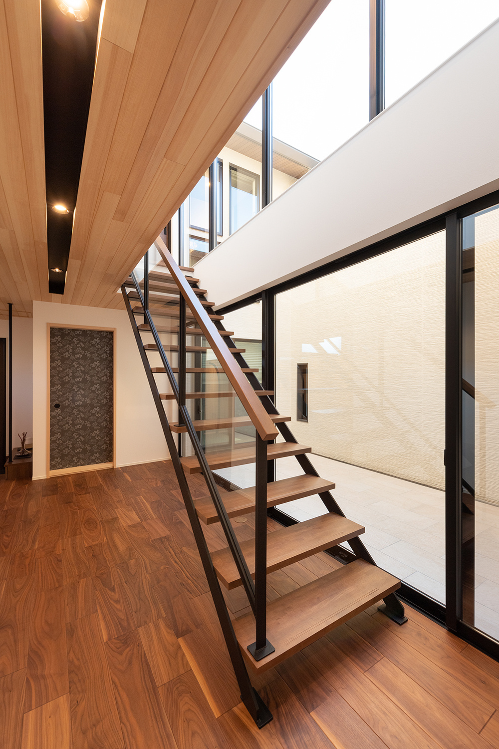 住宅街に佇む中庭から光と風がそそぐホテルライクな家｜重量木骨×ビルトインガレージ