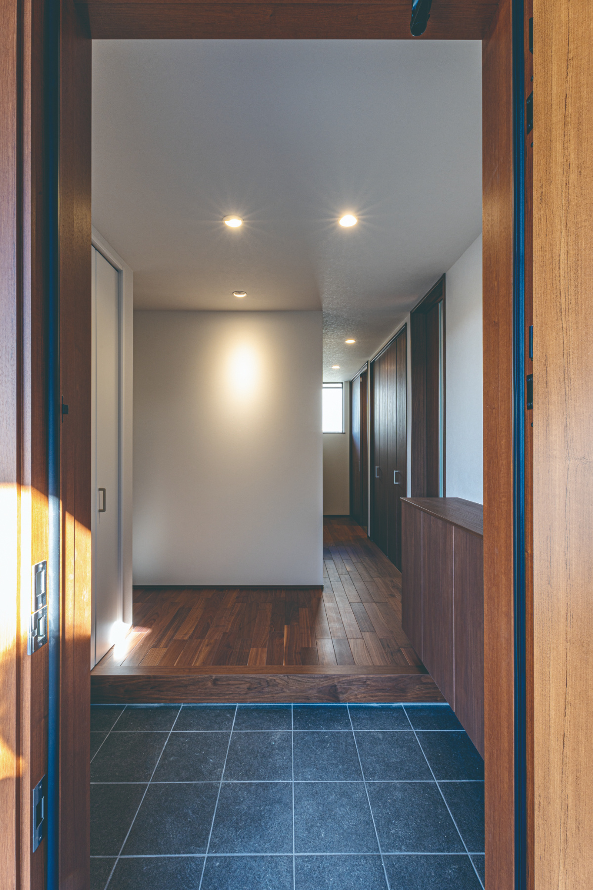 ダークブラウン×青みがかったブラックタイルで高級感のある玄関