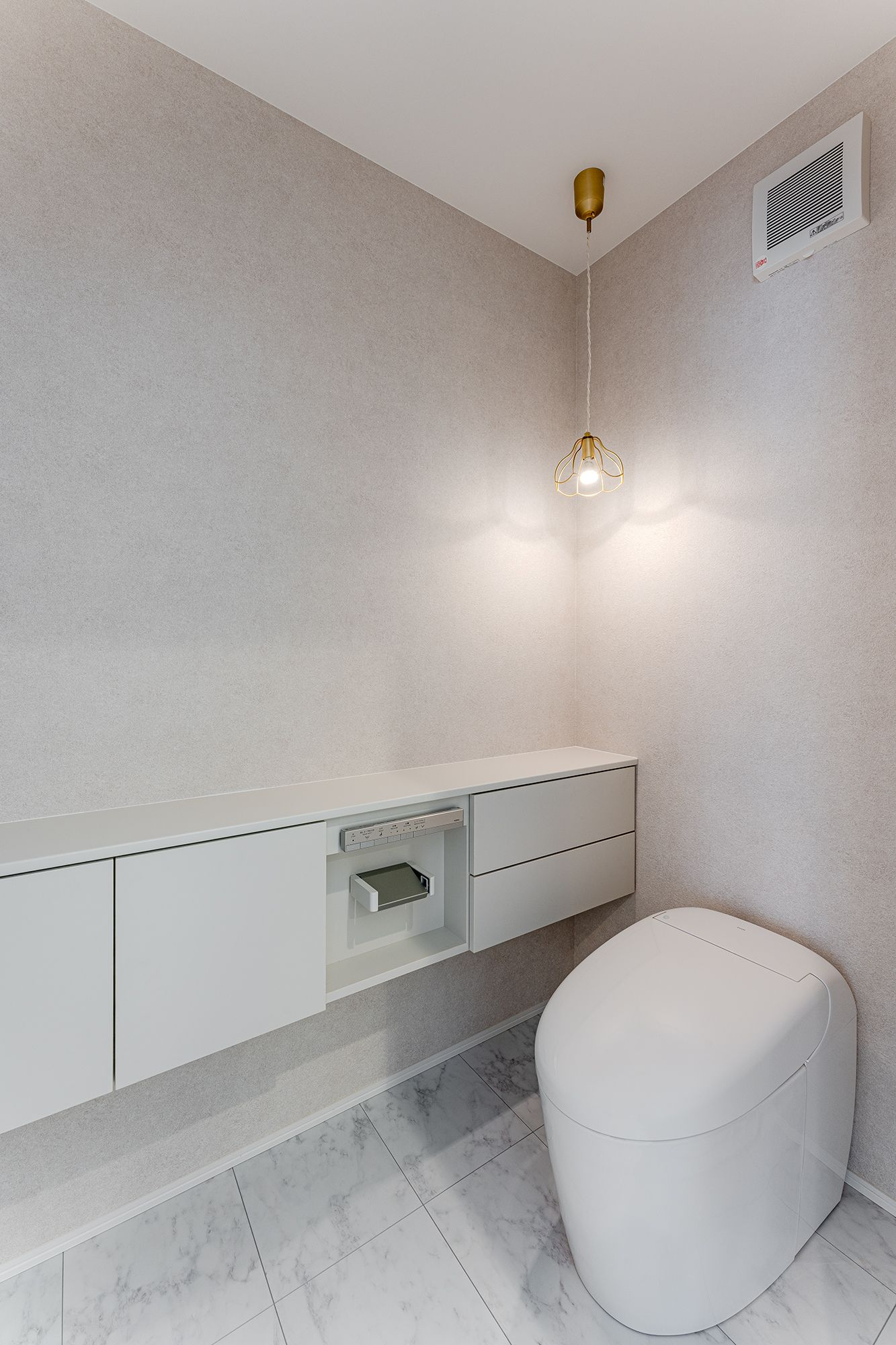 ベージュクロスとペンダントライトが調和するトイレ