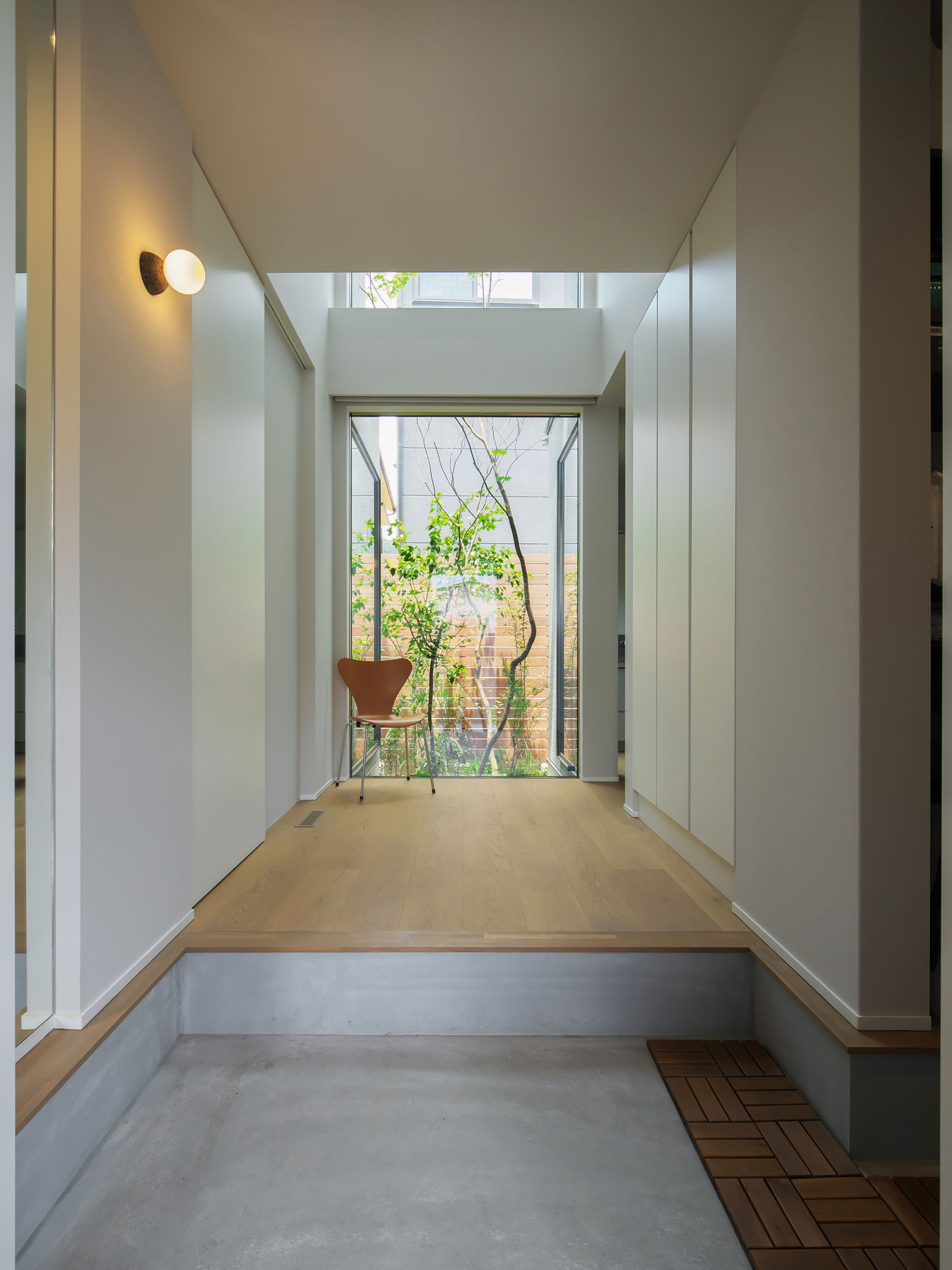 天井高を生かした開放的な玄関ホールは、正面に設けた大きな開口部から庭の緑を取り込みます。