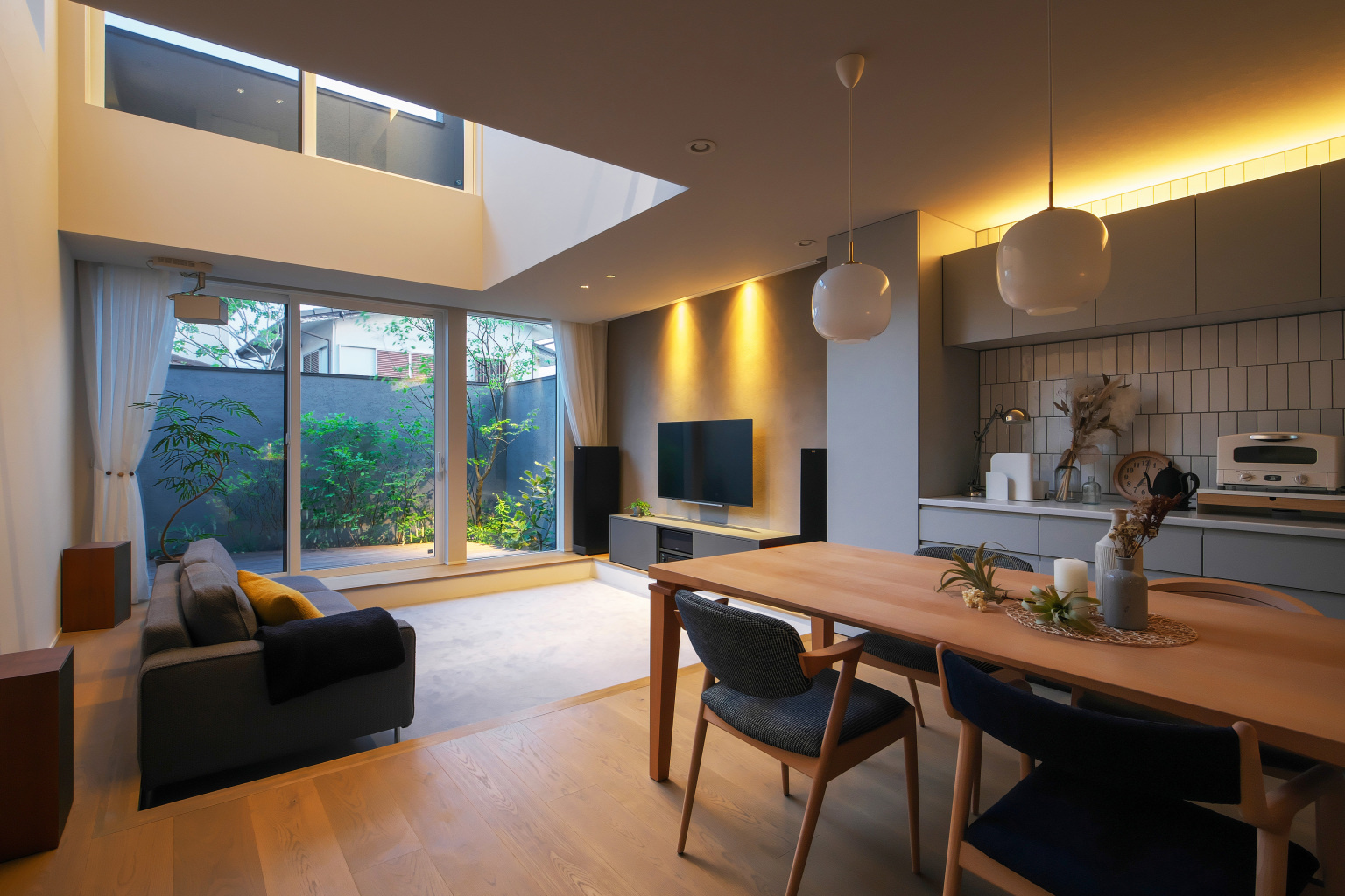 1段下がったリビングは大開口と吹き抜けによって、やわらかな光に満たされる明るい空間に。