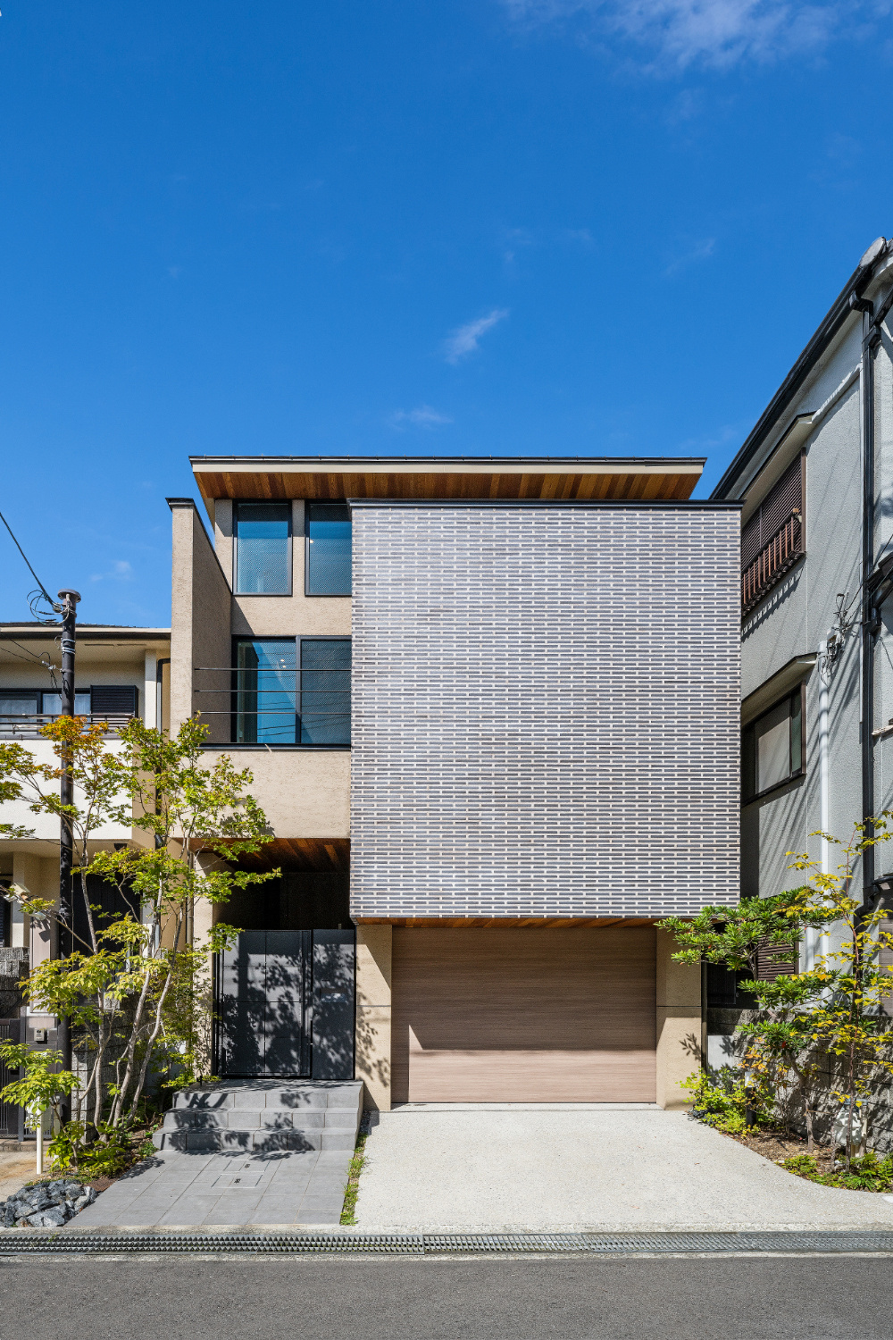 【神戸】ビルトインガレージとバルコニーに面したタイル壁が印象的な外観