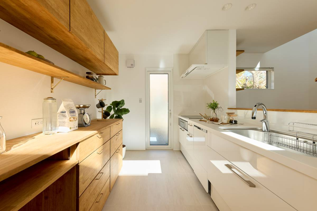白で統一したシステムキッチンと、木目が調和するキッチン空間