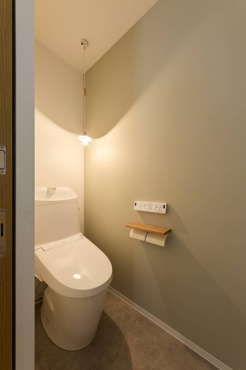 ペンダント照明とグレーアクセント壁の落ち着いたトイレ