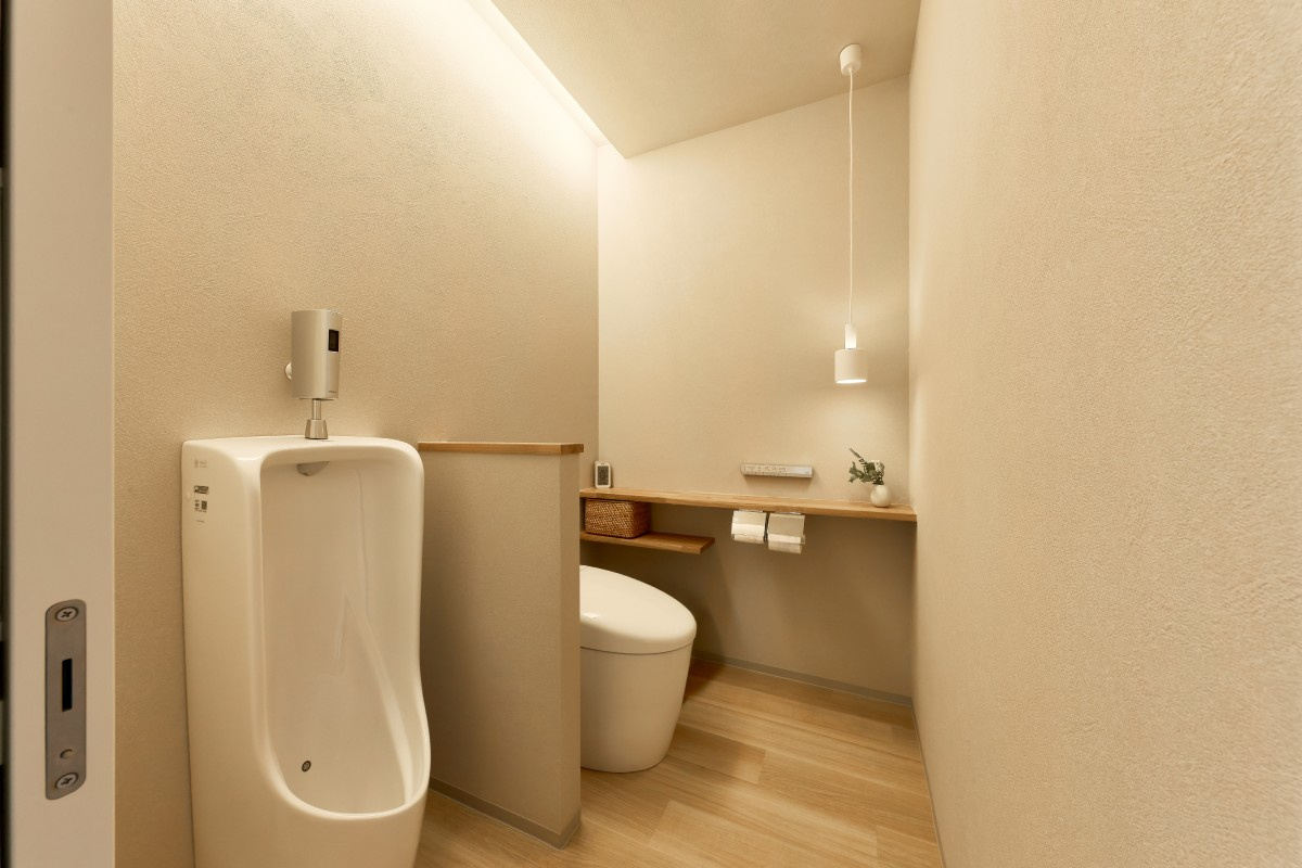 グレートーンの落ち着いたトイレ ― 小便器と大便器を分けた快適設計