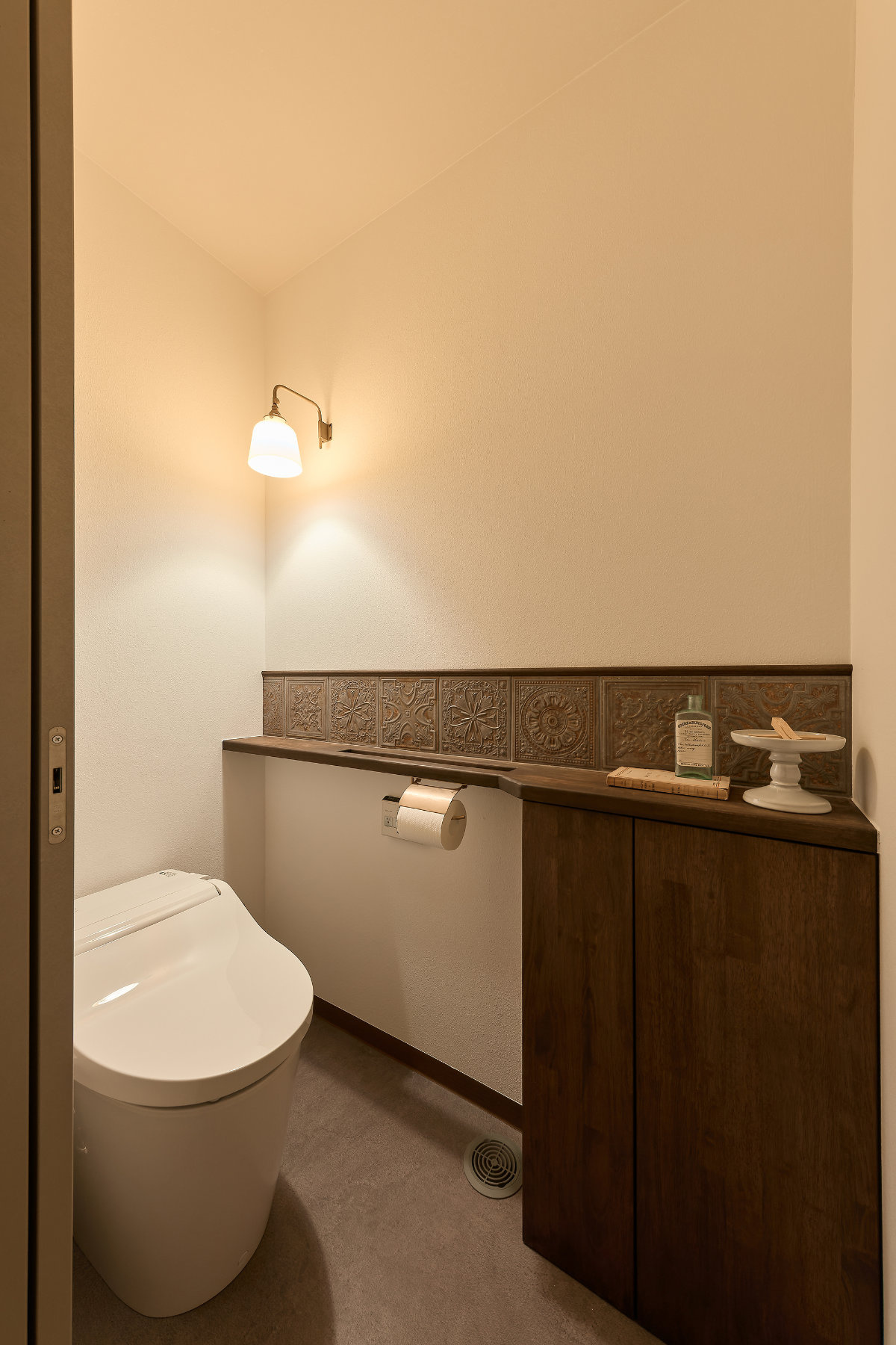 ペンダント照明とアクセントの壁タイルが特徴のトイレ