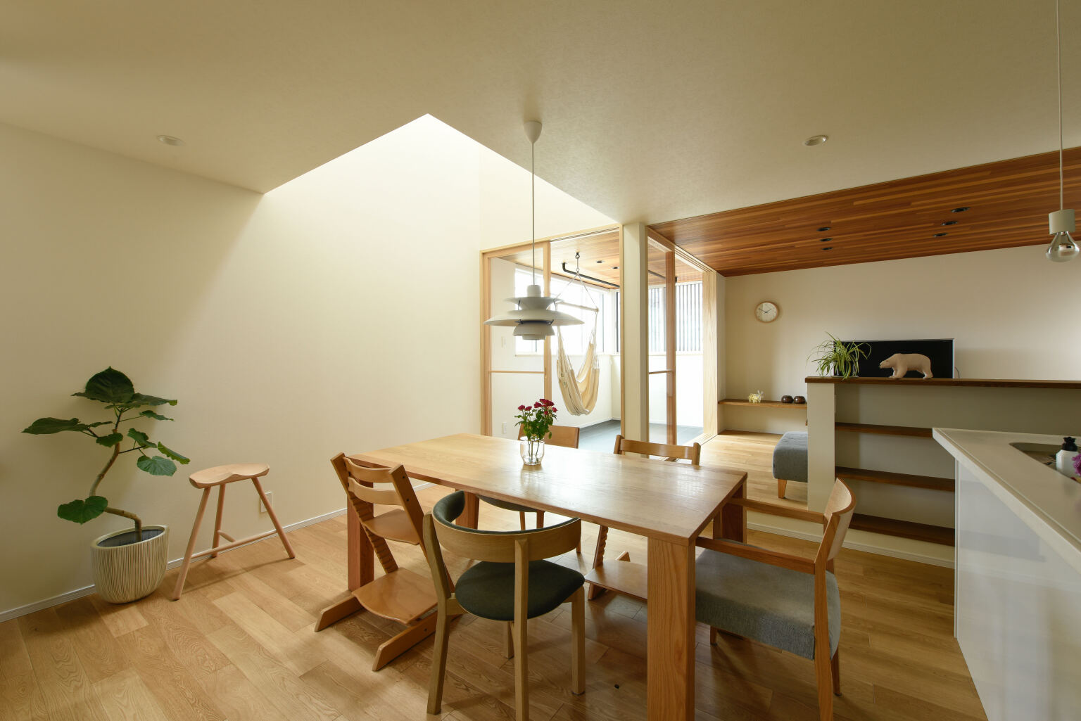 太陽光を取り込む中庭のような役割のサンルームと木の温かみあふれる狭小住宅のLDK