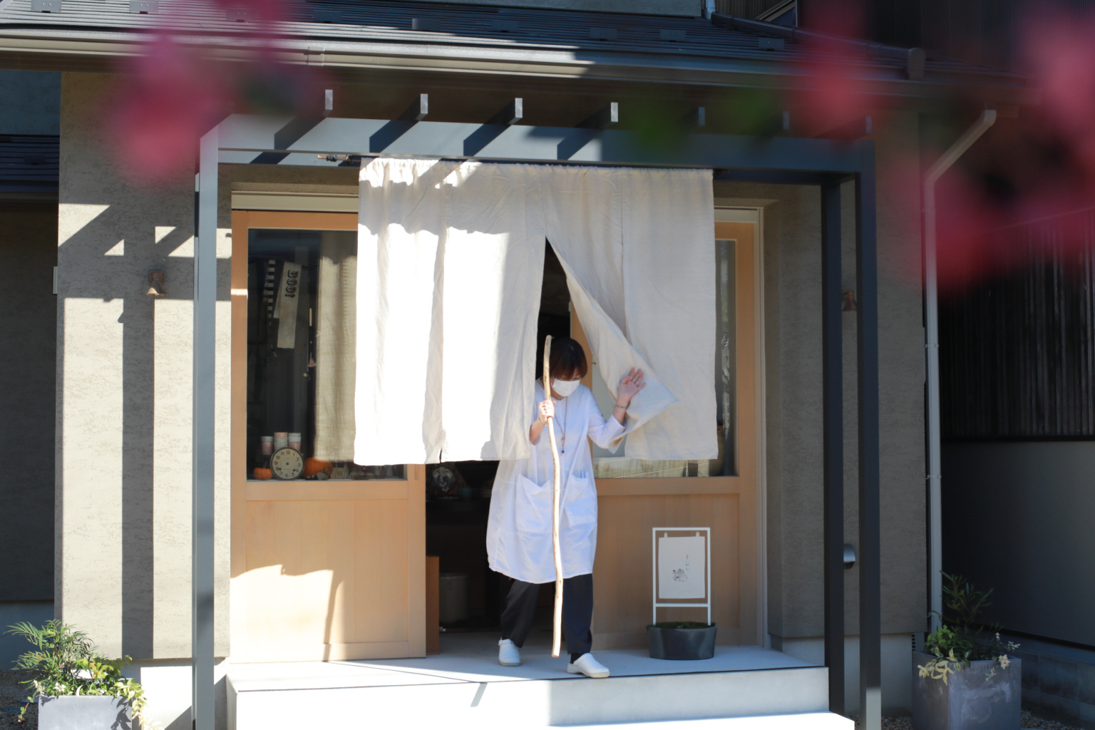 白い暖簾が優しくお客様を迎える、奥様こだわりの雑貨店へのアプローチ